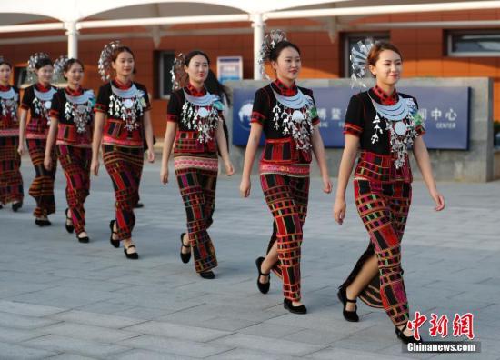 4月8日，身著黎族服飾引導員走過博鰲論壇新聞中心。博鰲亞洲論壇2018年年會在海南博鰲舉行。<a target=&apos;_blank&apos; href=&apos;http://www.chinanews.com/&apos;><p class=